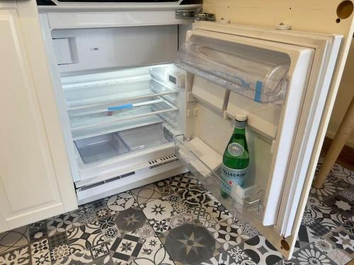 an open refrigerator with a bottle of water in it at Charm'in Champigny: Studio cosy, détente & travail in Champigny-sur-Marne