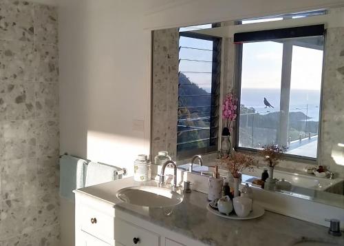 a bathroom with a sink and a large mirror at Belvedere in Kororo Basin