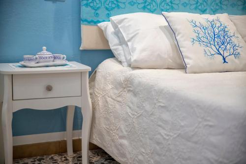 a bedroom with a bed and a nightstand with a white bedspread at Casa Vacanze San Michele in Alghero