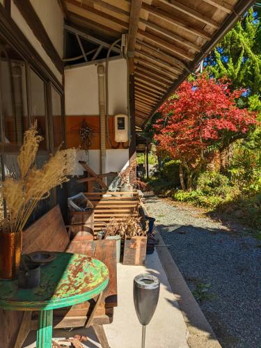 a patio with a table and a wooden roof at 　Komori Village GH ～小森ヴィレッジ ゲストハウス～ 自然の中にある庭付平屋一棟貸 in Obara