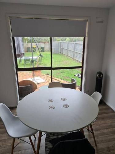 a white table and chairs in a room with a window at Ocean Grove - walk to Beach, Park, Cafe & Pub in Ocean Grove