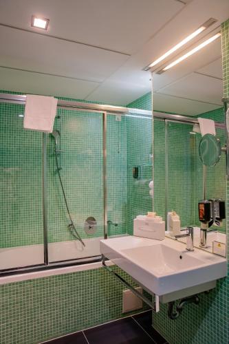 a bathroom with a sink and a shower at Hotel Thermana Park Laško**** Superior in Laško