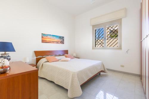 1 dormitorio con cama y ventana en Villino Dalila by BarbarHouse, en Torre Ovo