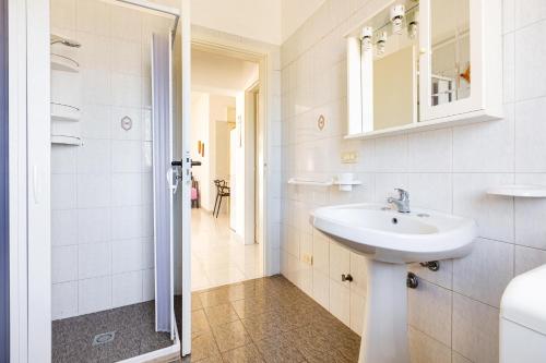 y baño blanco con lavabo y ducha. en Villino Dalila by BarbarHouse, en Torre Ovo