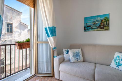 a living room with a couch and a balcony at Casa Vacanze San Michele in Alghero