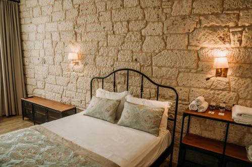 a bedroom with a bed and a stone wall at Nill's Stone House otel in Çeşme