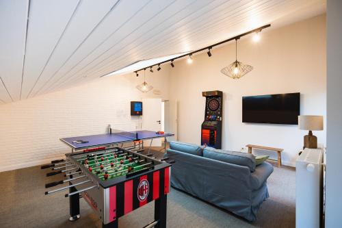 a living room with a ping pong table and a couch at Village du Caillou in Dinant