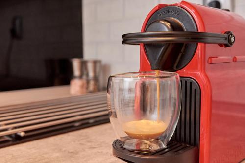 een rood koffiezetapparaat met een kopje koffie bij Florina Sky Loft in Florina