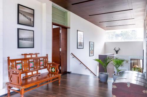 a living room with wooden furniture and a staircase at Stars By The Bay & BBQ Grill by StayVista in Dabolim