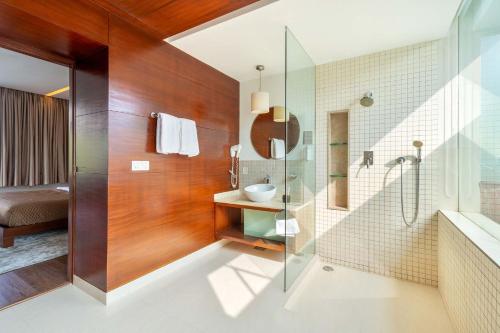 a bathroom with a glass shower and a sink at Stars By The Bay & BBQ Grill by StayVista in Dabolim