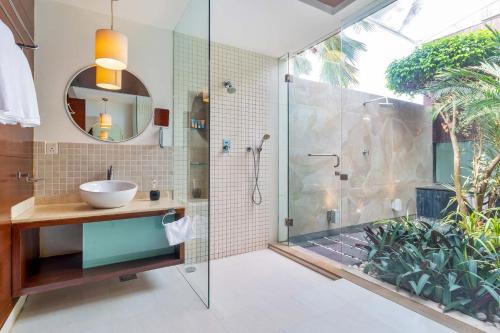 a bathroom with a glass shower and a sink at Stars By The Bay & BBQ Grill by StayVista in Dabolim