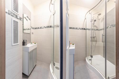 ein Bad mit einer Dusche, einem Waschbecken und einem WC in der Unterkunft SuperApart Ciasna 8a in Warschau
