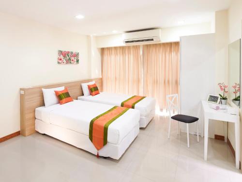 Bang SuにあるThe Plimplace Hotelのベッド2台とデスクが備わるホテルルームです。
