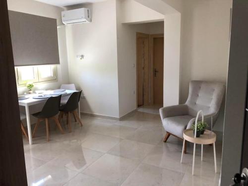 a living room with a table and a chair at Bounatsa Studios & Apartments in Nydri