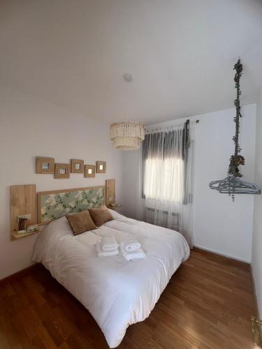 a bedroom with a large white bed with two towels on it at Casa Rural La Chicuela in Los Villares