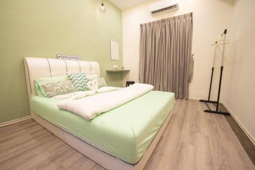 a green bed in a room with a window at Casa Le Rock in Kuah