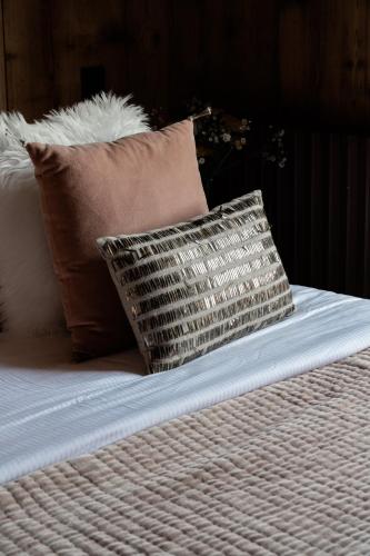 a bed with two pillows on top of it at Hôtel Les Roches Fleuries in Cordon