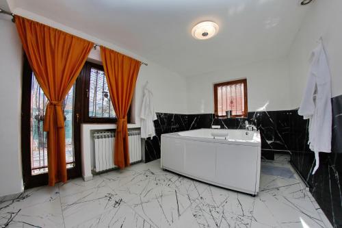 a bathroom with a tub and a sink in a room at Hedonist Spa Apartment in Sarajevo