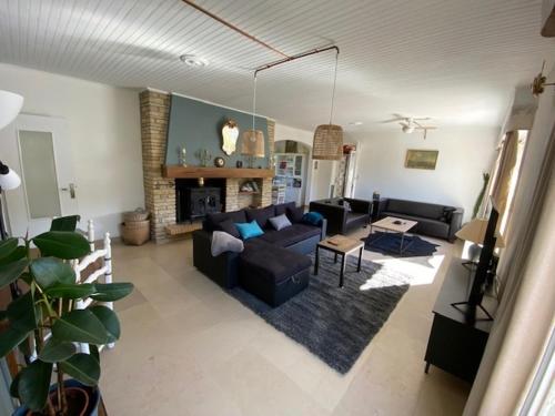 un salon avec un canapé et une cheminée dans l'établissement Un Havre de paix en bordure de la Dordogne, à Lalinde