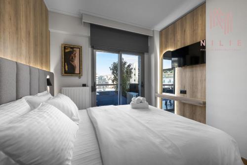 a bedroom with a large white bed with a window at Green Tulip, Nilie Hospitality MGMT in Thessaloniki