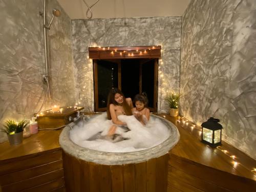 two girls sitting in a bath tub with lights at เติมเต็มคาเฟ่&แคมป์ปิ้ง by สวนเขาจุก in Ban Noen Sombun