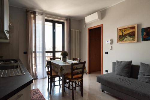 een keuken en een woonkamer met een tafel en een bank bij Bed&Business Nick Bellezza-San Siro Stadio-Rho Fiera in Settimo Milanese