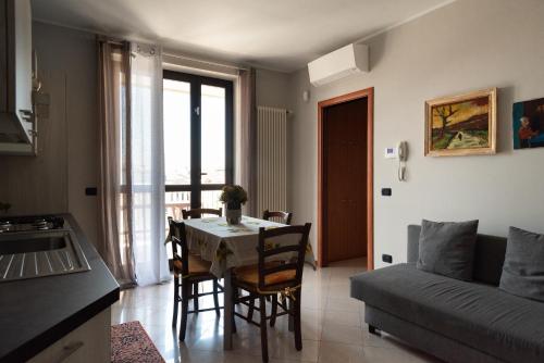 a kitchen and living room with a table and a couch at Bed&Business Nick Bellezza-San Siro Stadio-Rho Fiera in Settimo Milanese