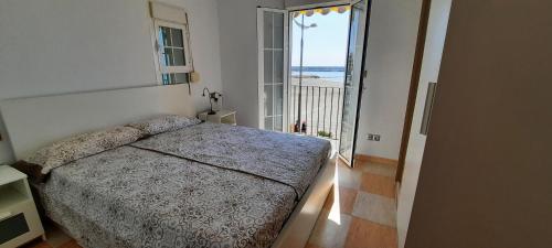 a bedroom with a bed and a view of the ocean at POS, Apartamento pesquero en primera linea in Era de Soler