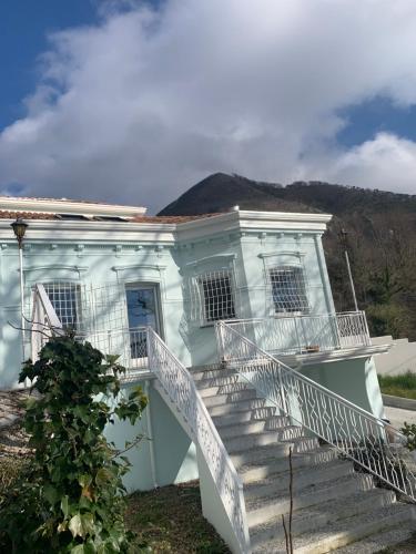 uma casa branca com escadas com uma montanha ao fundo em VillaOmbrosa em Lauria Inferiore