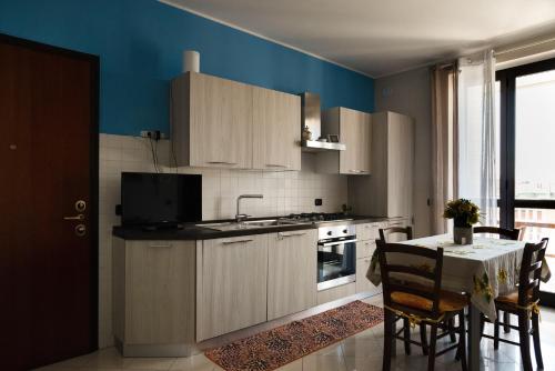 una cucina con armadi bianchi e un tavolo con tavolo. di Bed&Business Nick Bellezza-San Siro Stadio-Rho Fiera a Settimo Milanese