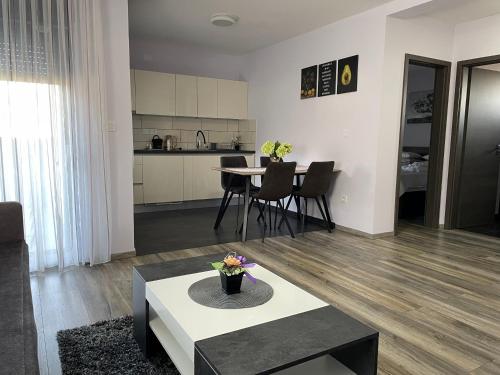 a living room with a table and a kitchen at Apartments Dora Sveti Martin na Muri in Sveti Martin na Muri
