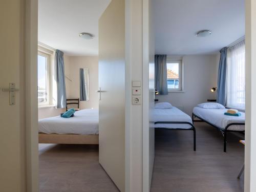 a room with two beds and two windows at Maxime 205 - Kustpark Village Scaldia in Hoofdplaat