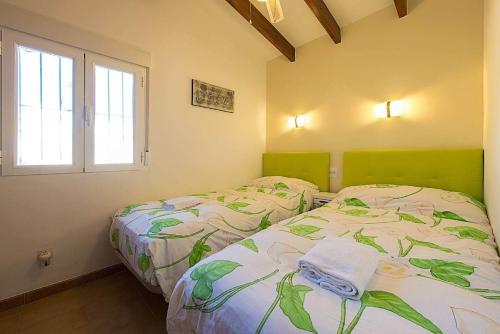 1 dormitorio con 2 camas y ventana en Villa Neus - PlusHolidays, en Calpe