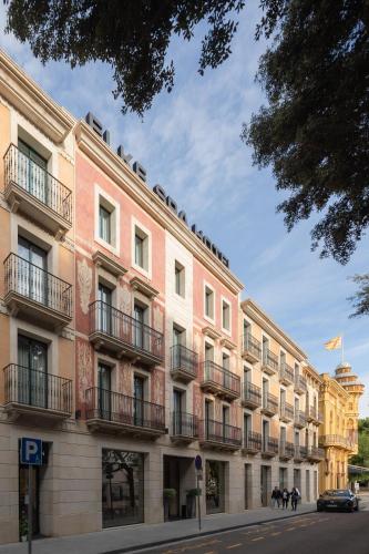 a large pink building with balconies on a street at Boutique Hotel Élke Spa Superior in Sant Feliu de Guixols