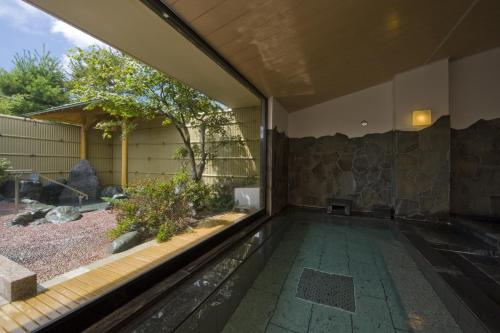 a room with a large window and a bench in it at Tagaogi in Yamanakako