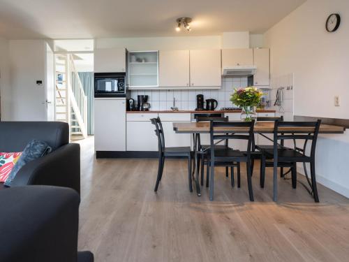 uma cozinha e sala de jantar com mesa e cadeiras em Antibes 254 - Kustpark Village Scaldia em Hoofdplaat