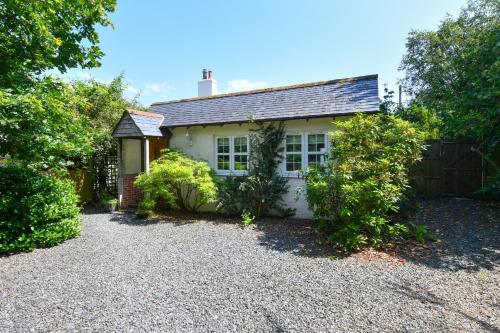 een wit huis met een hek en een grindoprit bij Wrens nest in Newton Stewart