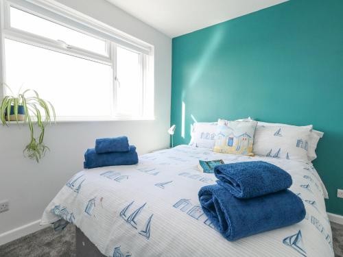 a blue bedroom with a bed with blue towels on it at Lagoon View in Weymouth