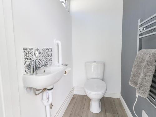 a white bathroom with a sink and a toilet at Lagoon View in Weymouth