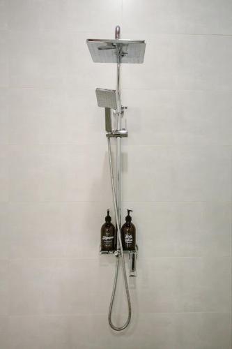 a shower with two bottles on a wall at Windbell Villa Hoi An in Hoi An