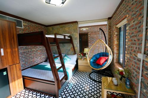 a small room with bunk beds and a wicker chair at Xuân Anh Homestay in Ninh Binh