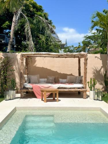 a bed sitting next to a swimming pool next to a house at Villa Mahuwa in Canggu