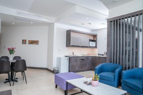 a living room with blue chairs and a table at Liv Weibdeh Hotel Suites in Amman