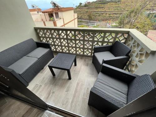 een balkon met 2 stoelen, een tafel en een leuning bij New 2023 full equipped stylish digi in Los Realejos