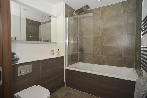 y baño con ducha, bañera y aseo. en Seaview Point, Superb 2- bedroom flat, 12th Floor en Southend-on-Sea