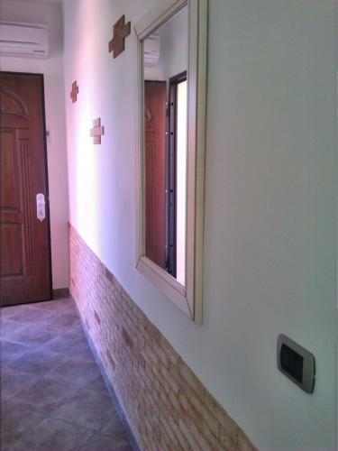 a mirror on the side of a wall next to a door at Hotel Sa Cralla Villasimius in Villasimius