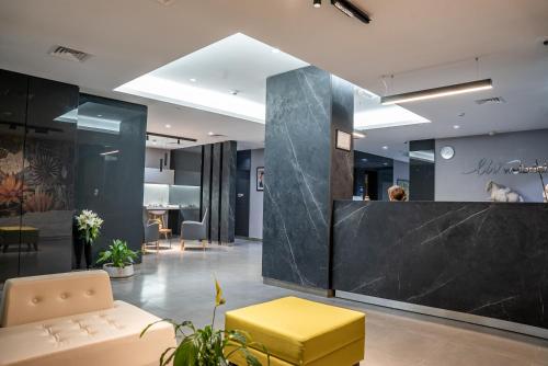 an office lobby with a yellow bench and a counter at Liv Weibdeh Hotel Suites in Amman