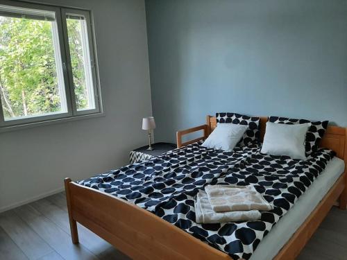 Schlafzimmer mit einem Bett mit einer schwarzen und weißen Bettdecke in der Unterkunft Comfortable villa with a hot tub 