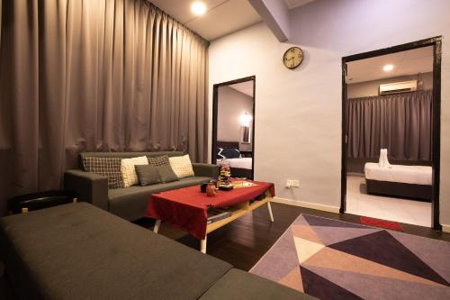 ein Wohnzimmer mit einem Sofa, einem Tisch und einem Spiegel in der Unterkunft Casa Le Grey in Kuah