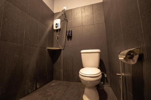 a bathroom with a toilet and a phone on the wall at Casa Le Grey in Kuah